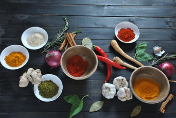Colorful various of fresh and dried herbs, spices for cooking. Spice and herb seasoning, paprika powder, cinnamon, red onion. garlic, basil, ginger root on dark background