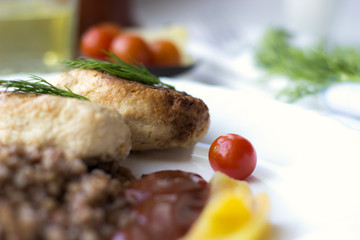 Chicken cutlets with buckwheat, herbs, ketchup and tomatoes