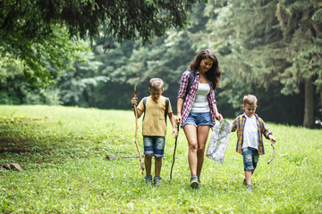 Fototapeta premium Mother and her little sons hiking trough forest .