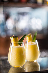 Two cocktails pina colada at barcounter in night club or restaurant