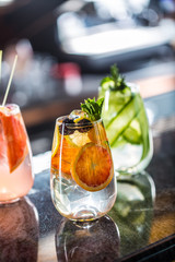 Tree colorful gin tonic cocktails in glasses on bar counter in pup or restaurant.