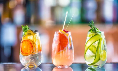 Gordijnen Boom kleurrijke gin tonic cocktails in glazen op toog in pup of restaurant. © weyo