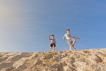 brothers playing in the dunes