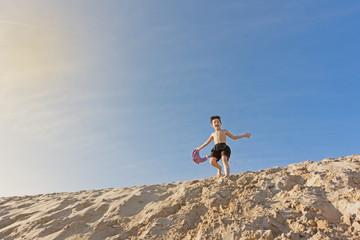 boy playing in the dunes