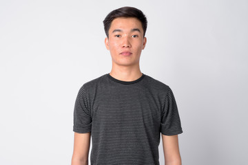 Face of young handsome Asian man against white background