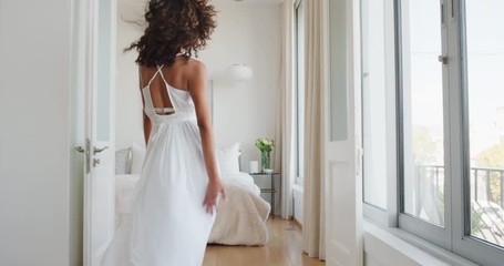 happy woman jumping on bed having fun laughing enjoying independent lifestyle celebrating freedom - Powered by Adobe