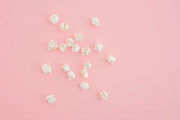 Crumpled pieces of paper on pink table.