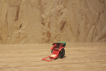 Miniature statue  and red vintage oriental rickshaw cab