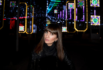 Pretty woman poses in the illuminated night.