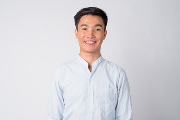 Face of young happy Asian businessman smiling