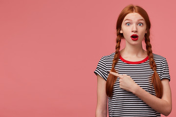 Amazed shocked worried teen girl with two red haired braids red lipstick open mouth in panic...