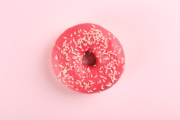 Top view composition of lush donut with colorful sprinkled icing, on bright paper textured...
