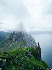  Adventurous man is standing on top of the mountain and enjoying the beautiful view during...