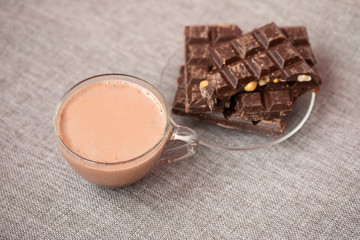 Hazelnut and almond milk and dark chocolate pieces tower on wooden background.