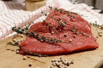 raw beef with white pepper and thyme on a cutting board
