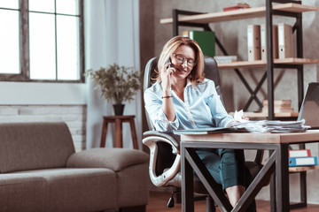 Beautiful businesswoman feeling good receiving call from husband