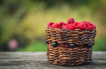 Fototapeta na wymiar ripe raspberries in a basket on the background of nature