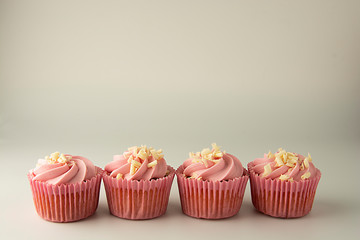 Pink, strawbery, fruit cupcakes isoalted arranged in row with copy space. Sweet dessert, shortcakes with cream. Birthday food, cake, muffin.