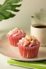Pink, strawbery, fruit cupcakes isoalted. Sweet dessert, shortcakes with cream. Birthday food, cake, muffin. Palm, monstera leaves on background. Summer dessert.