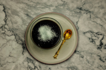 Chocolate mousse in portion glass bowl with gold spoon. Top view