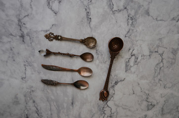 Various copper spoon on marble table. Kitchen utensils
