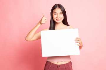 Fototapeta premium Young Asian woman show thumbs up with white blank sign.
