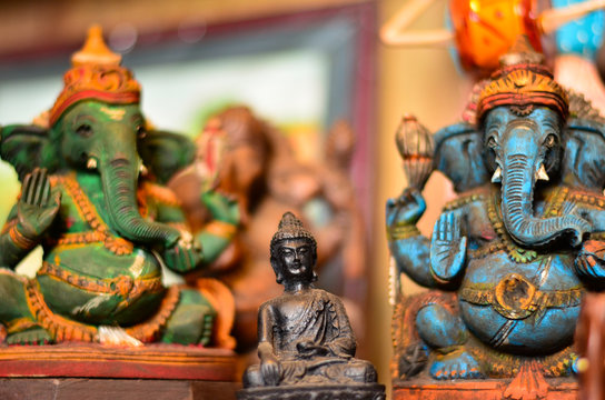 Miniature Hindu god statues of Ganesha, and Buddha made of clay and water pained exhibited by a road vendor at a roadside shop