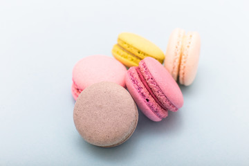 Colorful cake macaron or macaroon on turquoise pastel background from above. French almond cookies on dessert top view.