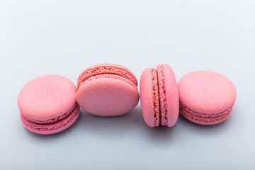 Fototapeta premium French pink macaroons cookies in rows on a light blue background