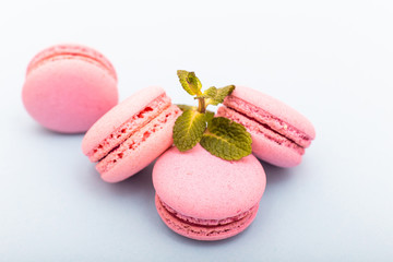 French pink macaroons cookies in rows on a light blue background