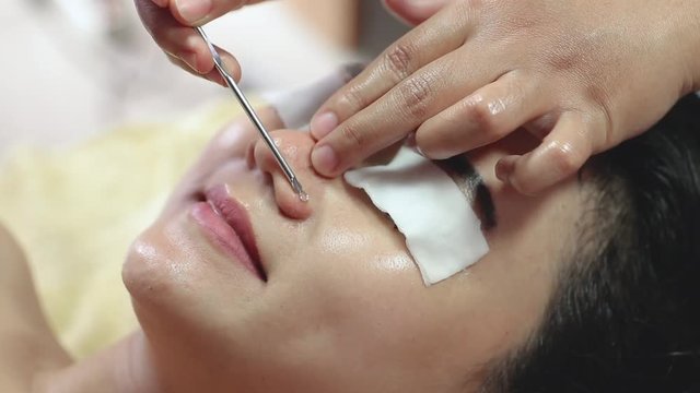 beautiful young asian woman getting blackhead suction treatment at spa salon