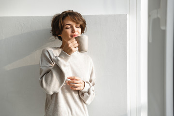 Smiling young woman having cup of tea