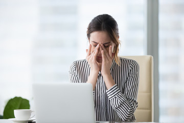 Tired businesswoman massaging eyes feeling strain fatigue headache relieving pain