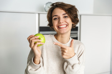Smiling young woman holding green apple