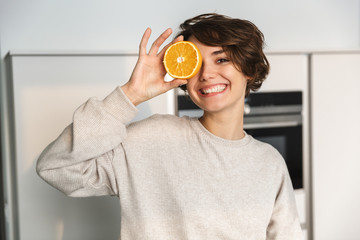 Smiling young woman holding orange