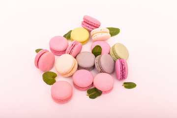 Fototapeta na wymiar Group of sweet pink and white mini macarons on soft pink paper background with copy space for adding text