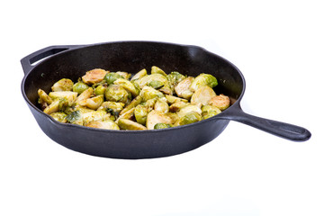 Roasted Organic Brussels sprouts in a Cast-Iron Skillet isolated on white background.