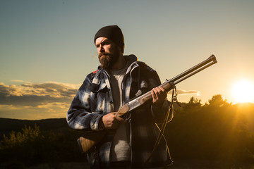Rifle Hunter Silhouetted in Beautiful Sunset. Hunter in the fall hunting season. Hunting is the...