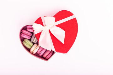 macaroons cookies on a heart box with red ribbon bow isolation on a white background
