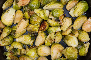 Roasted Organic Brussels sprouts in a Cast-Iron Skillet like background.