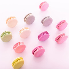 Colorful macarons cake, top view flat lay, line sweet macaroon on color white isolated background. Minimal concepts falling macaroons pattern above, food background