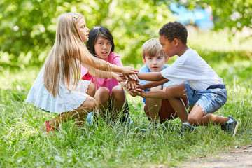 Multicultural group of children is stacking hands
