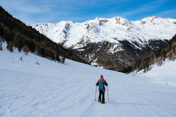 Fototapeta na wymiar Woman on a snowshoe tour in the italian alps