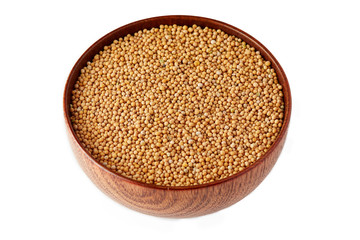 Organic yellow mustard seeds in wooden bowl isolated on white background
