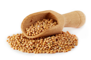 Organic yellow mustard seeds in wooden scoop isolated on white background