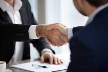 Closeup view of male hands shaking at meeting making deal