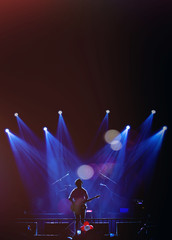 Asian Musician playing the guitar on black background with spot light and lens flare, musical concept