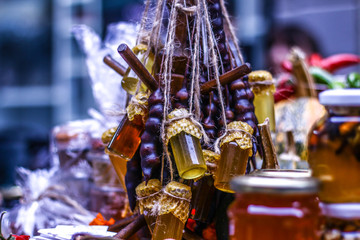 Jars and honey sticks with natural honey on shelf in shop. Sale of natural honey in market. Production of honey.