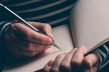 Close up of woman's hand writing in notebook