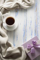 Cup with Coffee, Scarf, Gift on the White Wooden Table. Concept of Spring